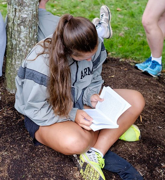 Student reading under a tree