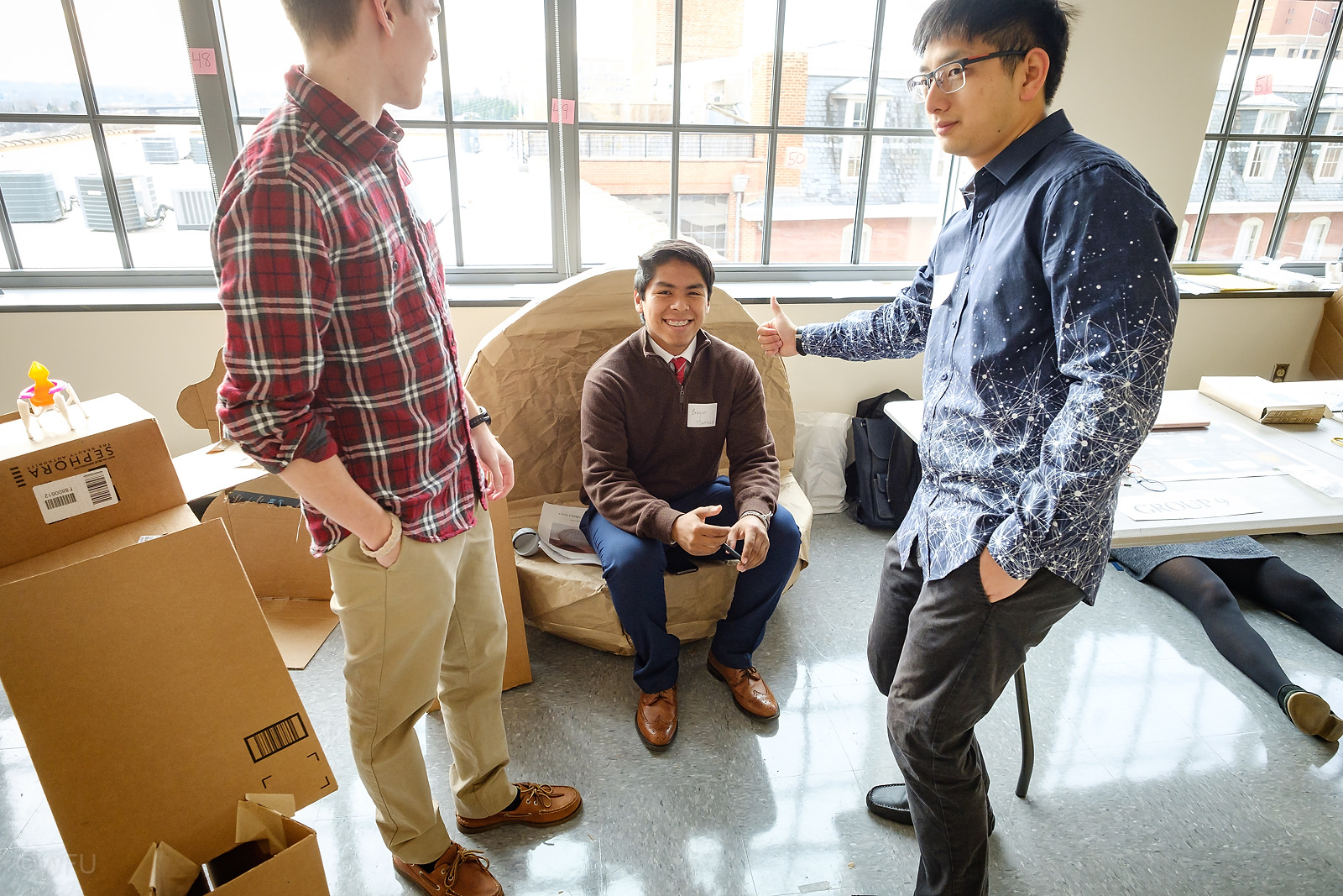 Engineering students at an end-of-semester gallery walk showcasing their cardboard chair designs