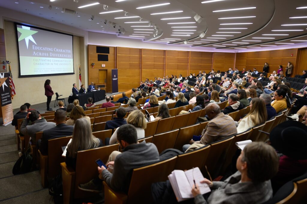 Wide shot of conference in auditorium