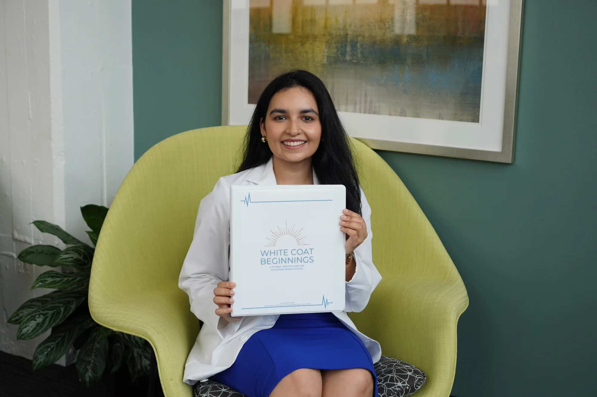 Geetika Verma (MD '29) holding up her student guidebook White Coat Beginnings.