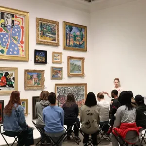 Students look at art in a gallery.