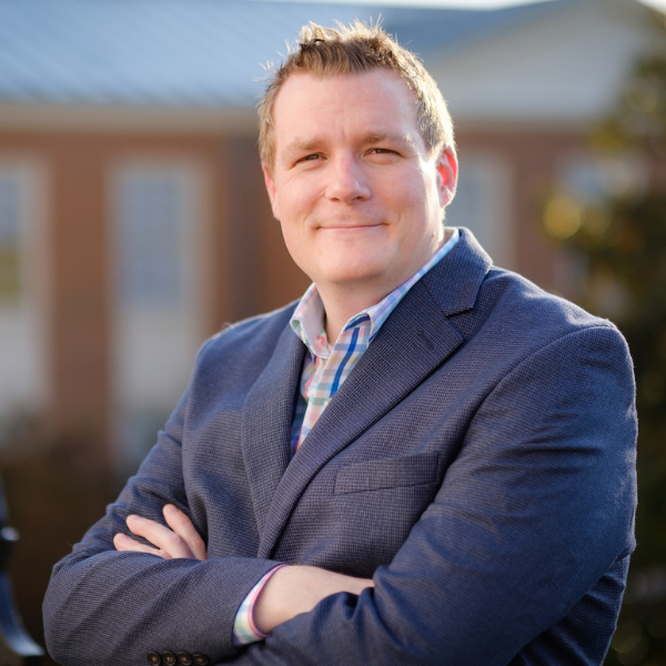 Man in dark blue blazer with arms crossed