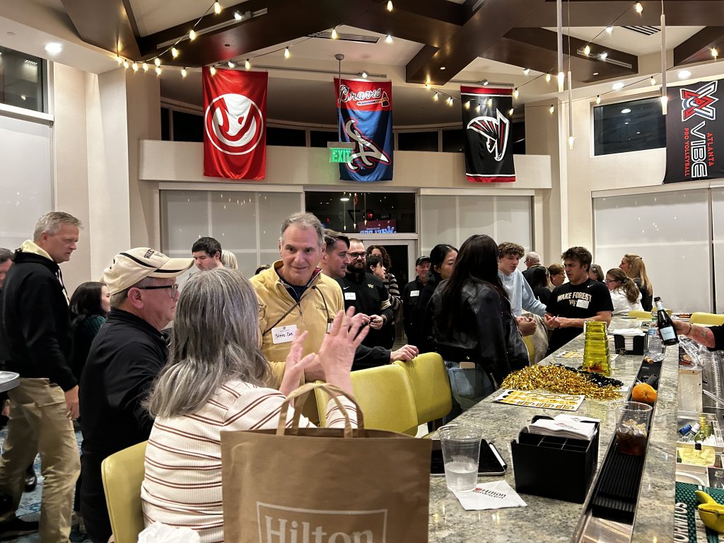 Wake Forest fans pack a room at the Hilton Garden Inn in Atlanta and chat among themselves at a WF vs GT pregame happy hour.