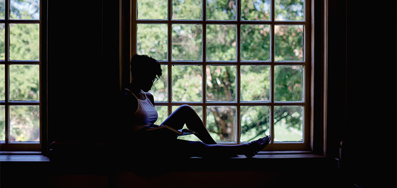 Student studying by a window