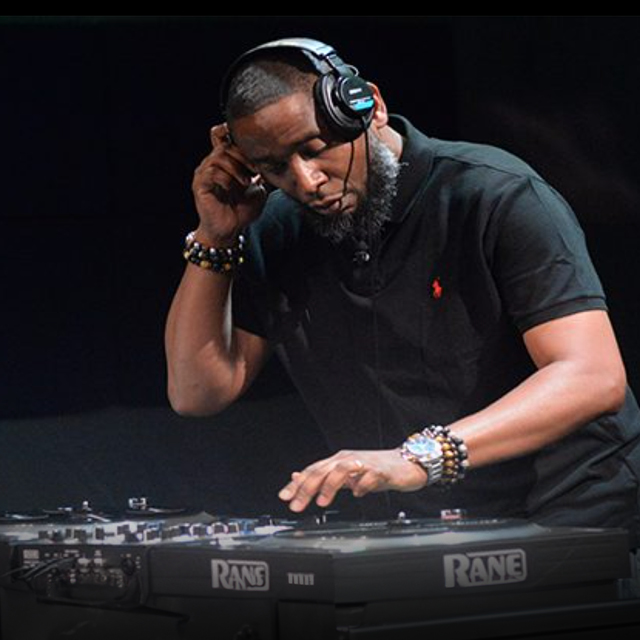 A Black man performs with a turntable