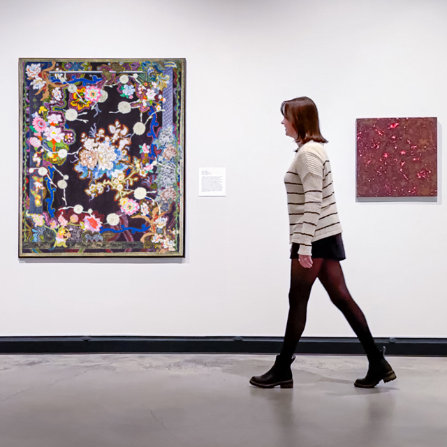 A woman walks through an art gallery