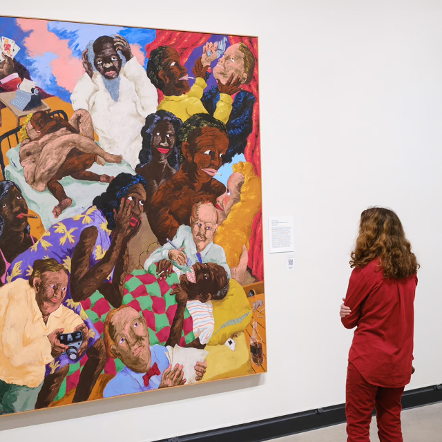 A woman looks at a large colorful painting in Hanes art gallery