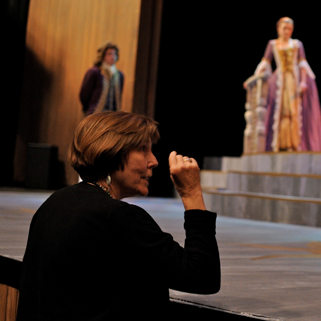 Sharon Andrews directs students in costume onstage