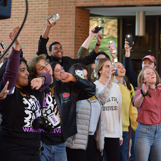 An excited crowd cheers at an outdoor arts festival performances