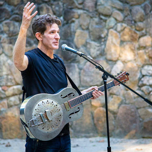 A man with a guitar performs