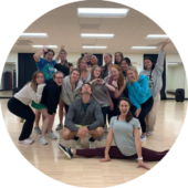 A group of people smiling in a dance studio