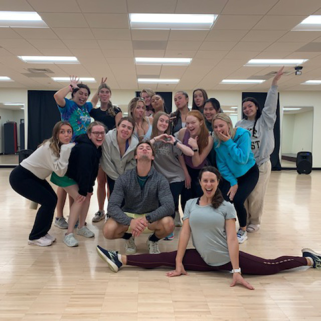 A group of people smiling in a dance studio