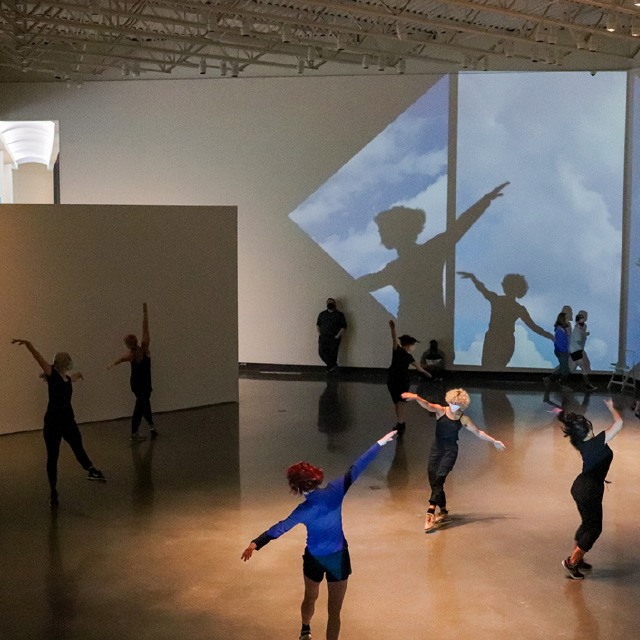 Dancers perform with live video installation in an art gallery