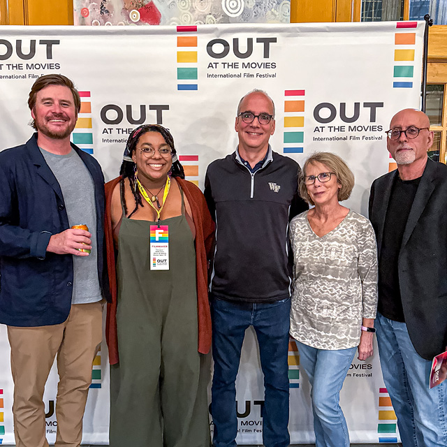 A group of people smile at the Out at the Movies film festival opening