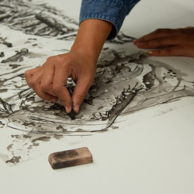 Close up of hands drawing with charcoal