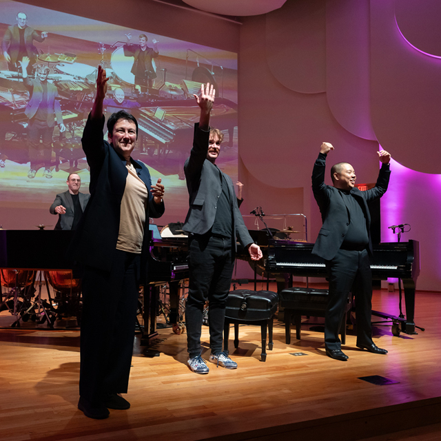 Three performers wave to an enthusiastic audience