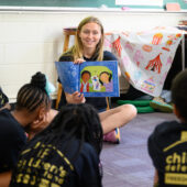 A Wake Forest student reads a picture book to local school children