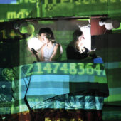 Students perform in a digital glitch-inspired projection environment