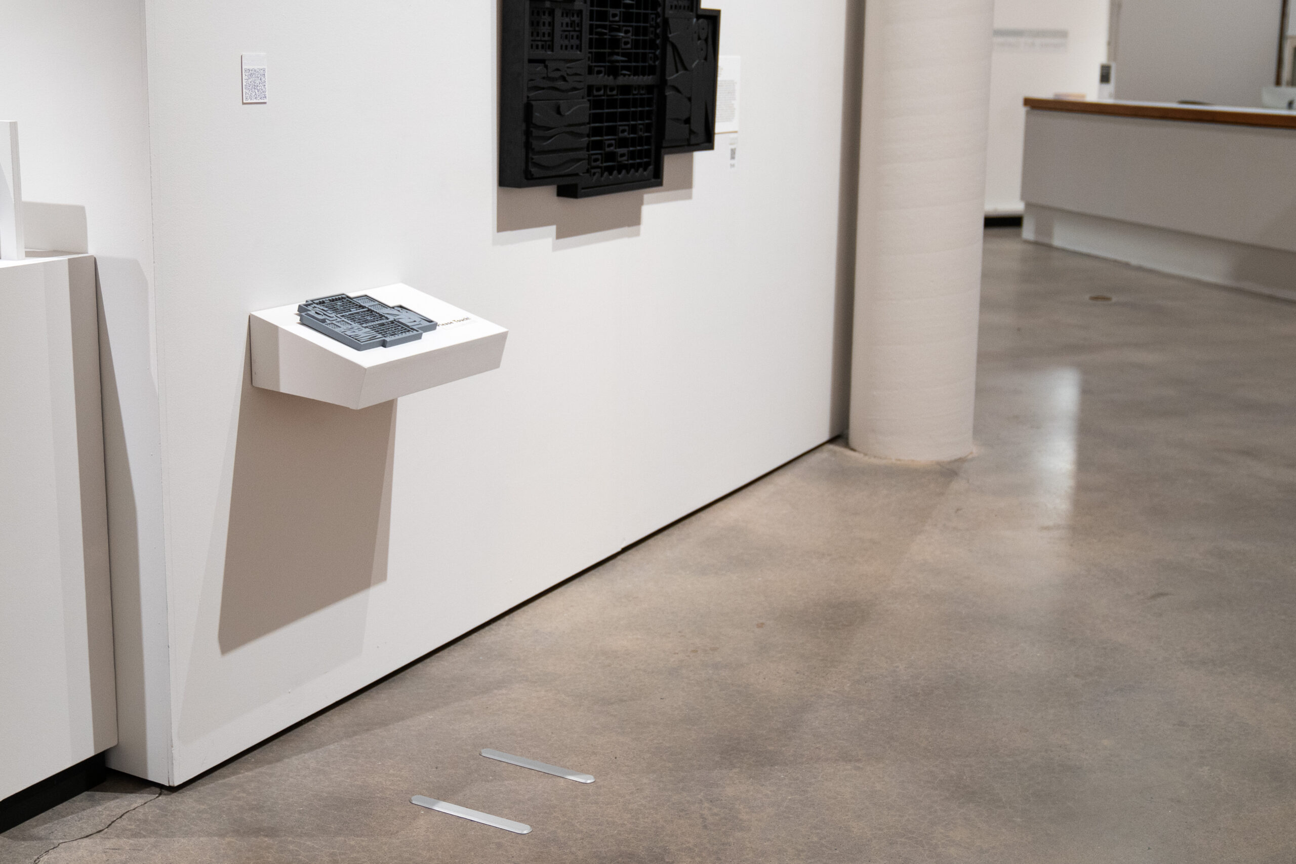 gallery show display with art, shelf with tactile guide, and locator bars