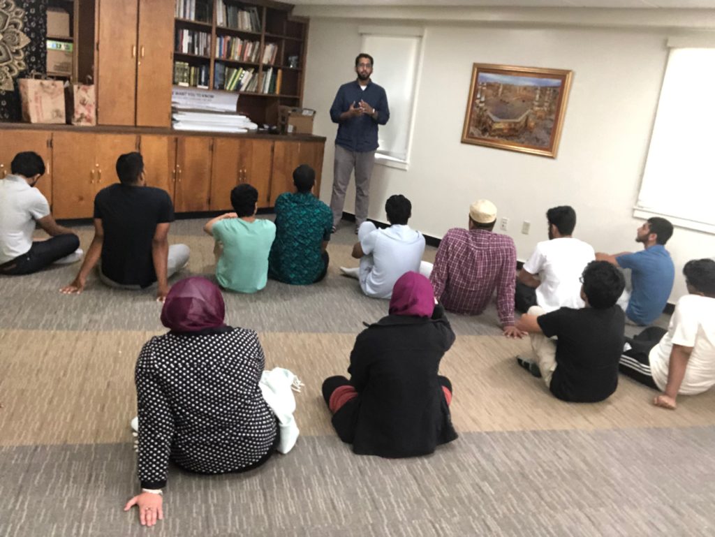 Image of students sitting in the Muslim Students Lounge and listening to the Friday Sermon.