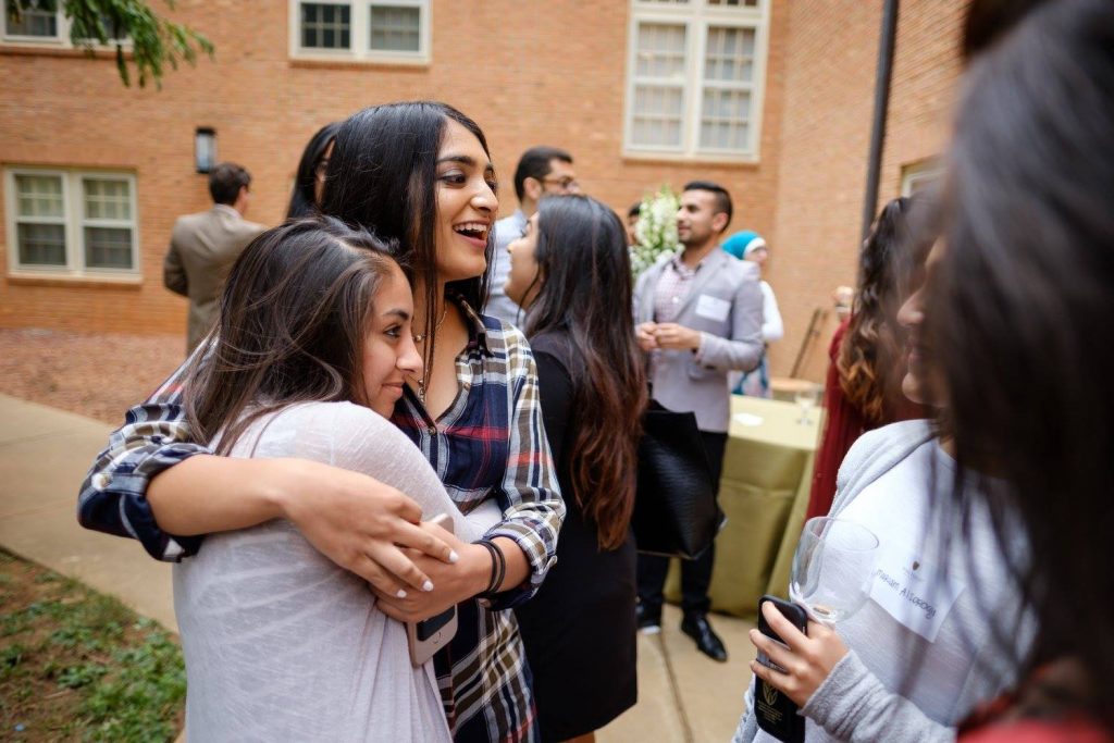 Muslim students hugging at the Dedication Ceremony for the Muslim Students Lounge.