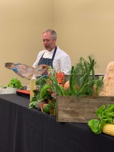 Chef William Dissen holding a fish he will be using for a cooking demonstration at Wake Forest. 