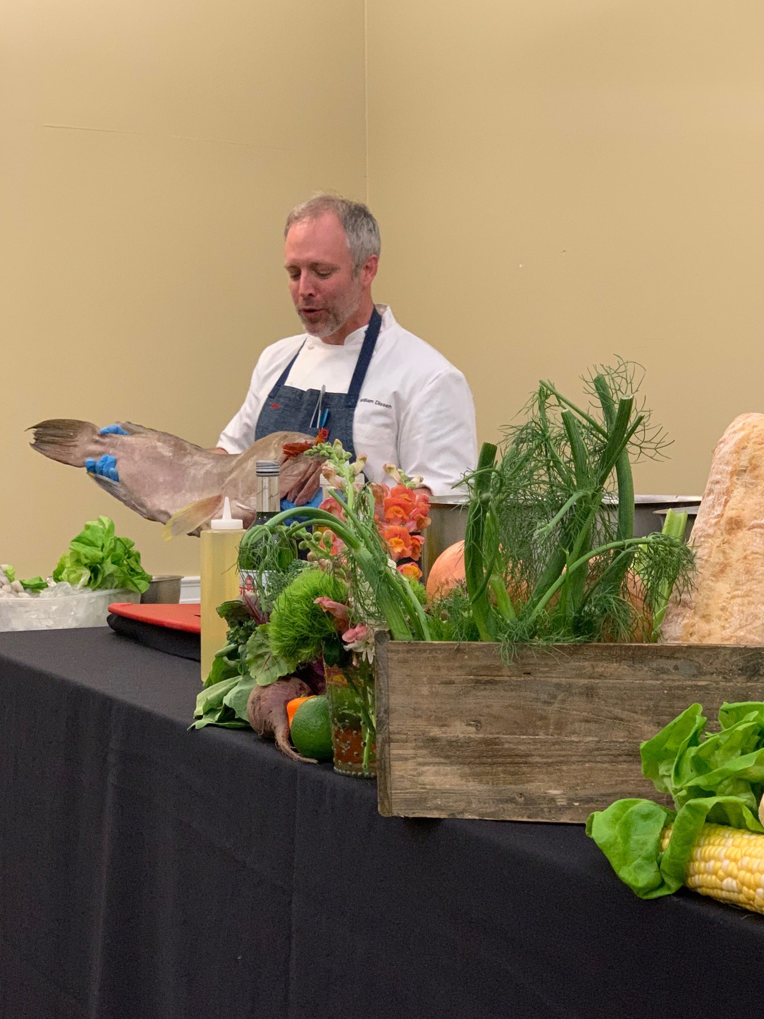 Chef William Dissen holding a fish he will be using for a cooking demonstration at Wake Forest.