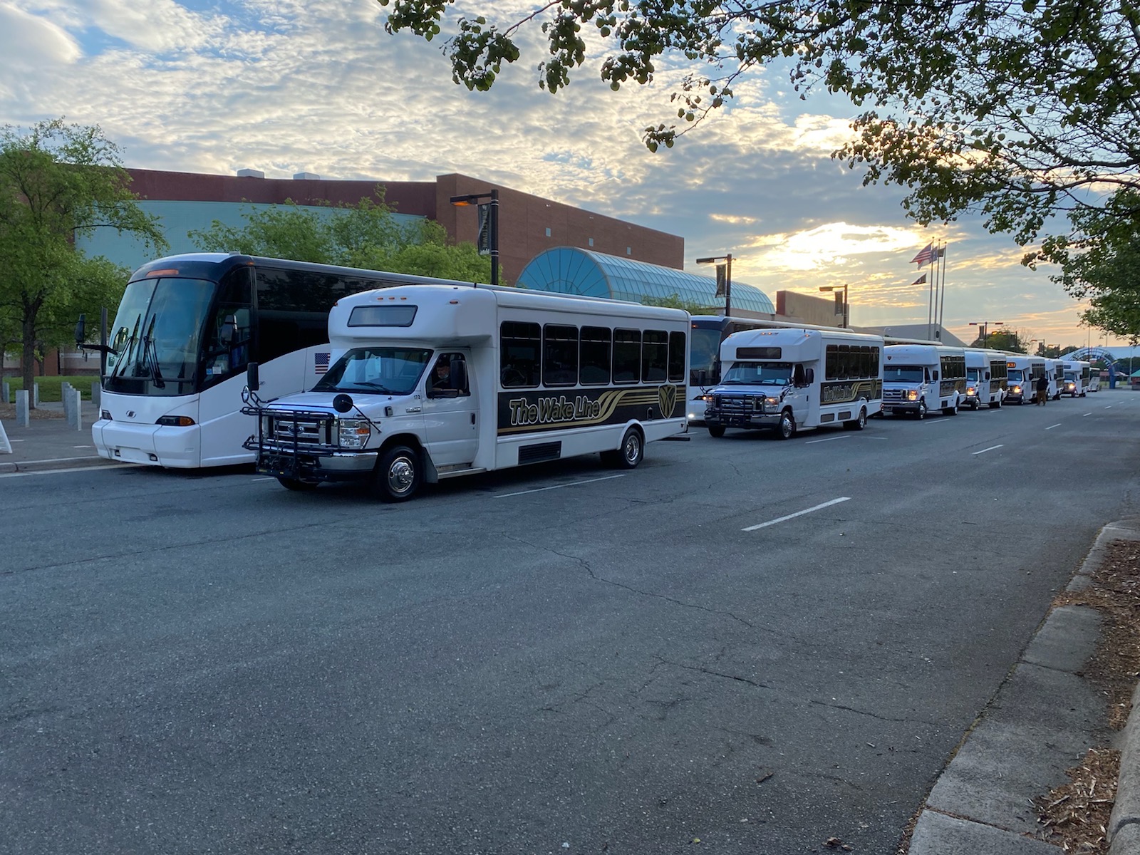 Wake Line Shuttles line up in front of the Coliseum to transport guests to 2022 Commencement. 