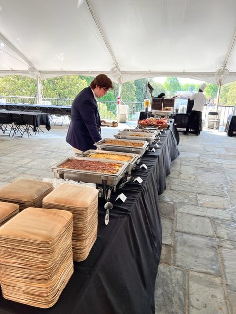 Buffet table set up under a tent for Commencement dining. 