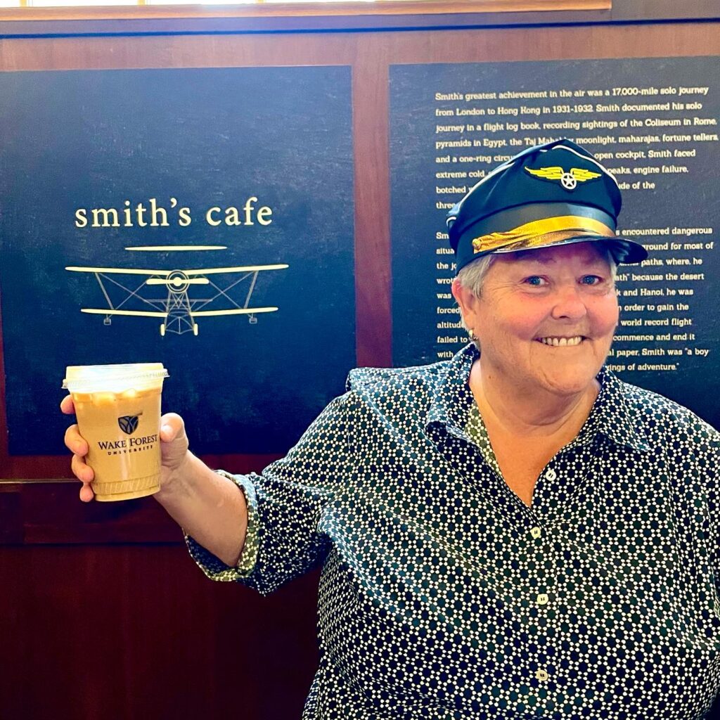 Harvest Table employee, Robin Day, poses for a photo with her coffee from Smith's Cafe. 