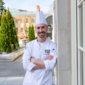 Photo of Chef Zachary Woodring outside the dining hall on a sunny day.