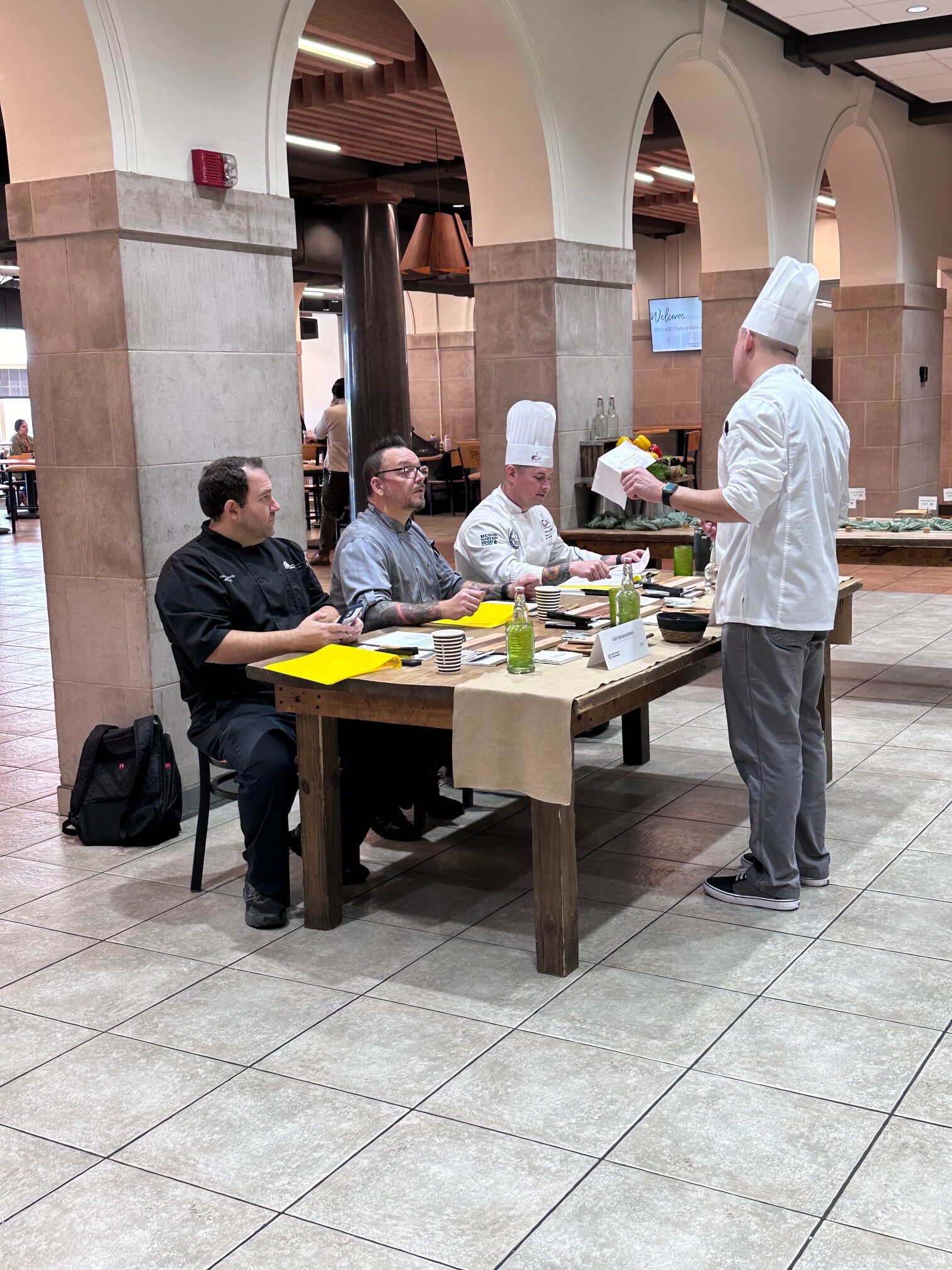 Panel of judges sitting at a table discussing contestant information.