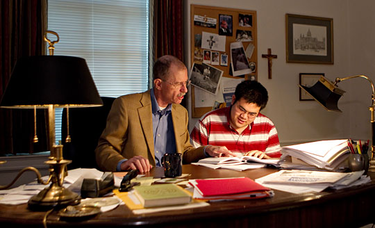 Dan Hammond and a student look at a book