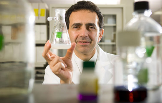 Anthony Atala looks at a beaker