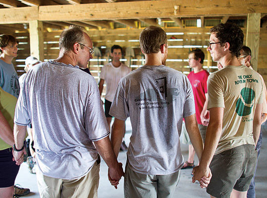 Men hold hands in a circle