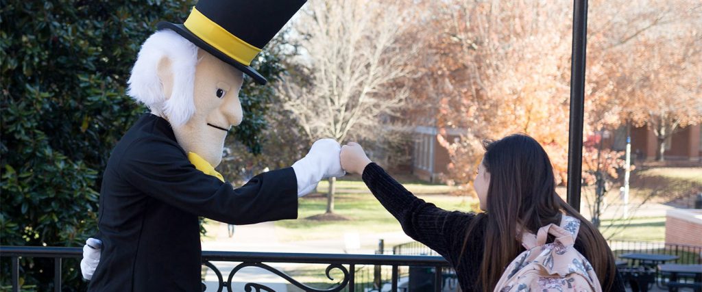 Student fist bumping with the Demon Deacon mascot