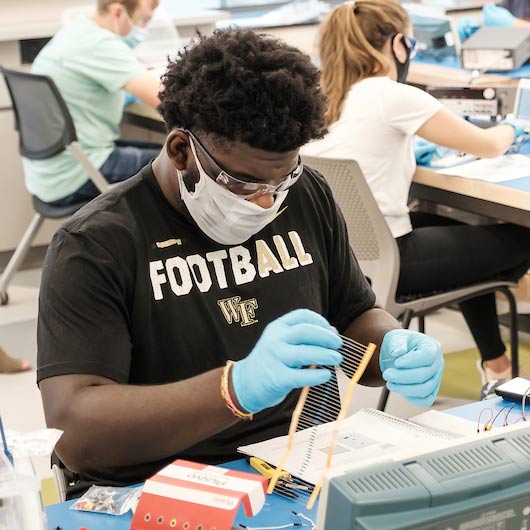 Wake Forest engineering students work on circuits with capacitors