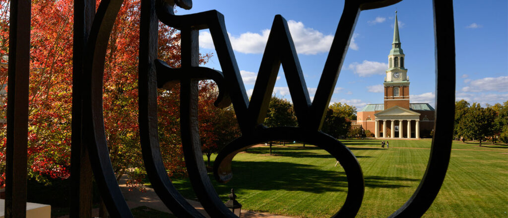 Wait Chapel and the quad seen through a Wake Forest ironwork symbol 