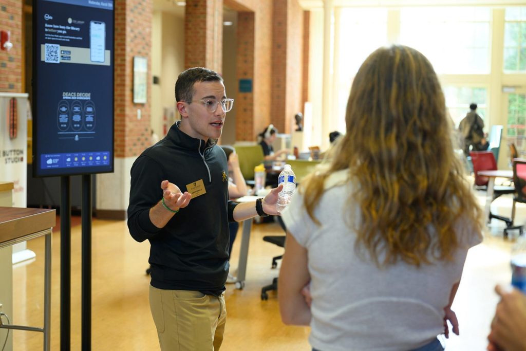 Student tour guide answers questions from visiting prospective students and their families.