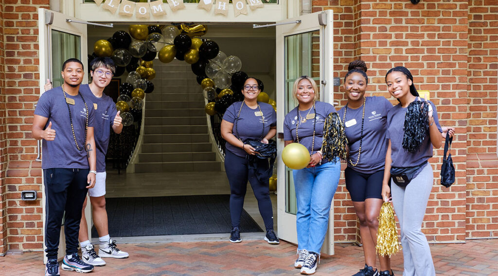 Resident advisors standing outside of a residence hall during move-in day