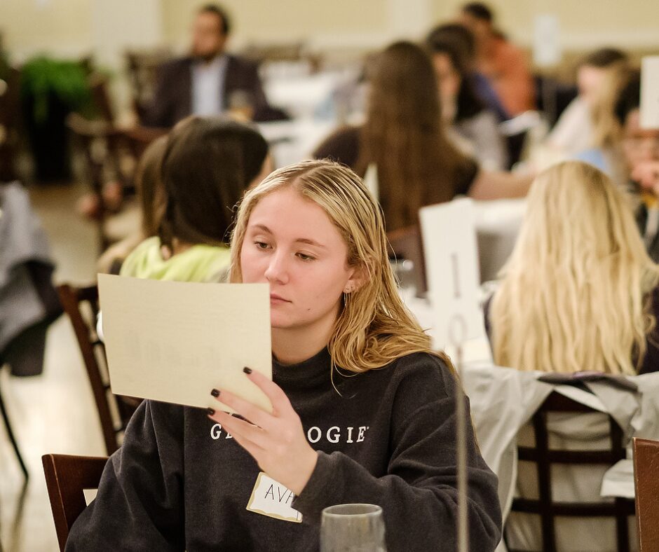 Wake Forest student lost in thought reading a paper. 