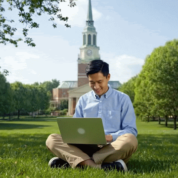 Male student completes his Handshake profile while seated on the Quad.