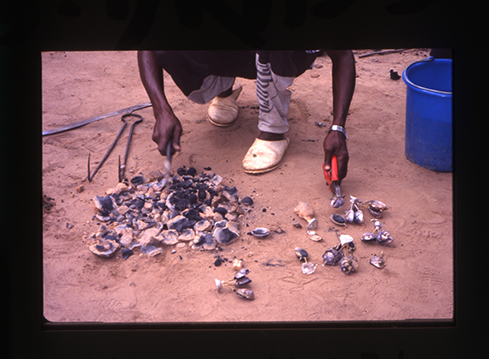 a man breaking clay molds with a hammer