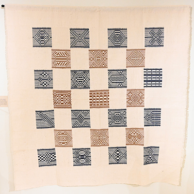 cream colored woven textile with blue and brown square designs