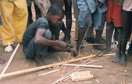 a boy making a toy car from wood scraps