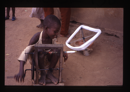 a child winds thread onto a wheel