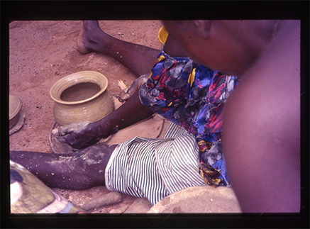 A woman shapes a clay pot