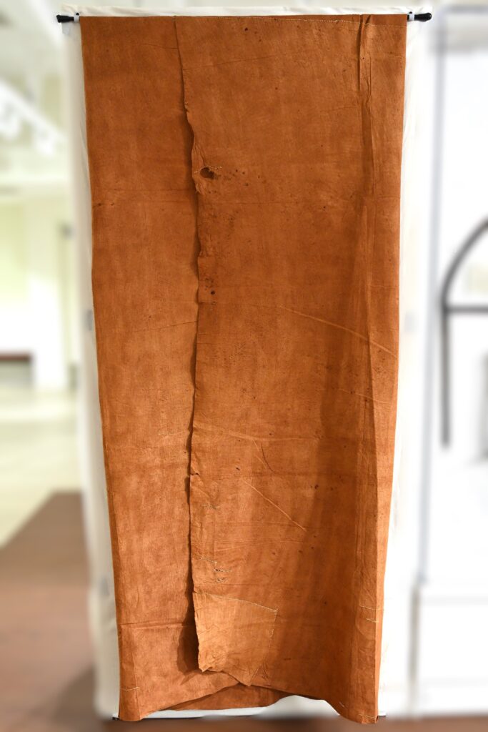 Large brown-orange textile folded over a rod