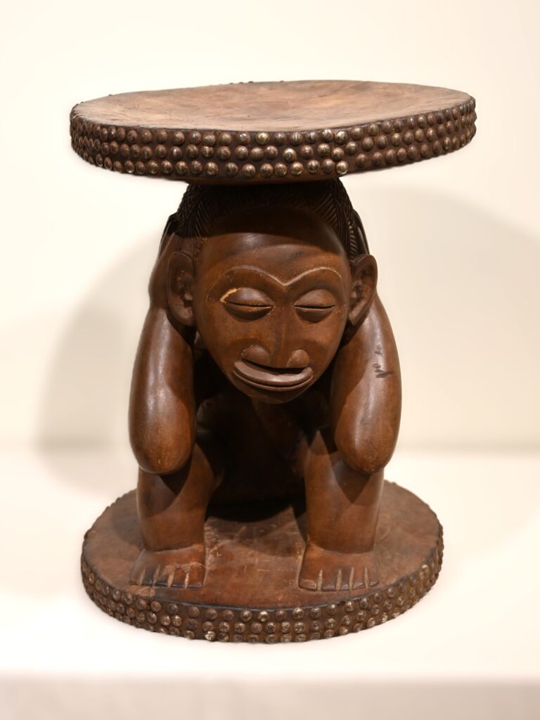 Wooden stool with crouched human figure forming the support under the seat