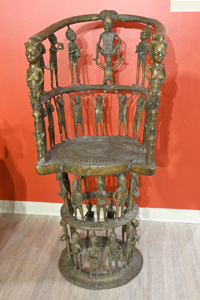 Brass throne with numerous human figures making up parts of the chair